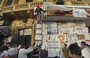 Egyptian activist on ladder at KFC.  Graphics exhibition during protests.